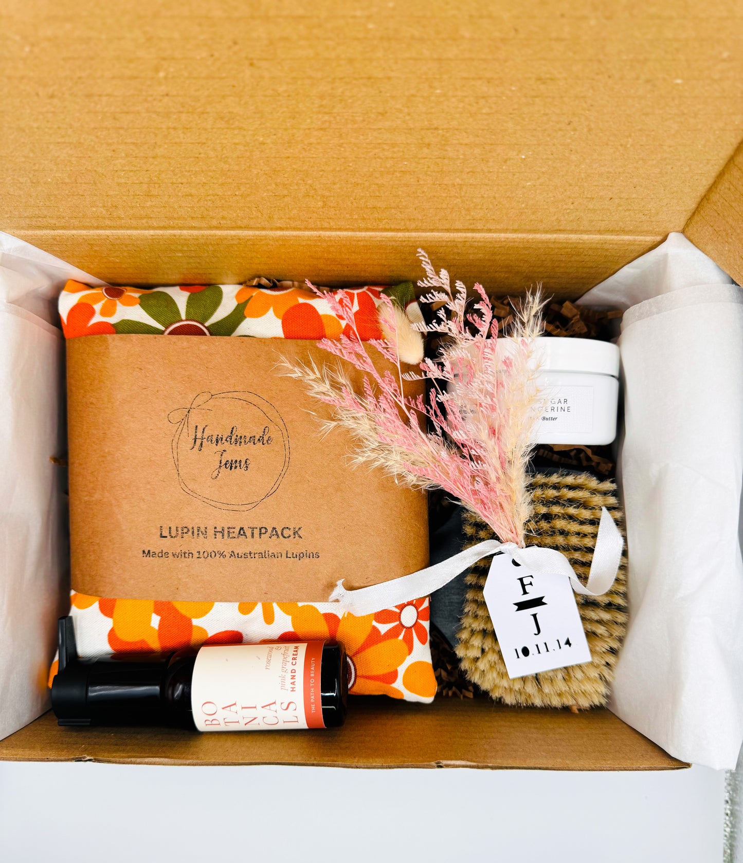 Box containing a heat pack, bottle, and other items with a visible brand tag.