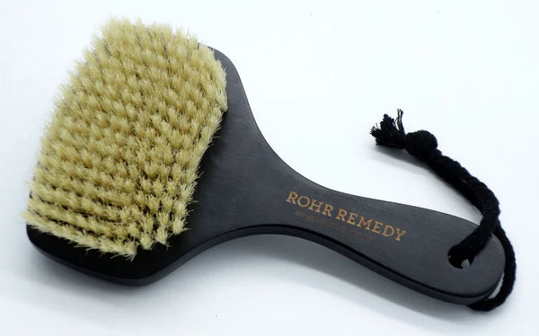 Gentle Scrubbing Brush with black handle and natural bristles on a white background
